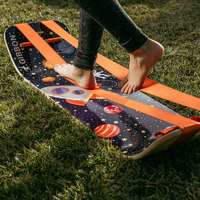 Person stepping onto an astro slackboard plus on grass