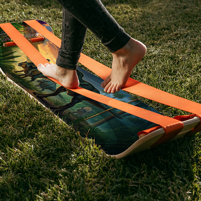 Person using a GIBBON Dino SlackBoard plus on grass