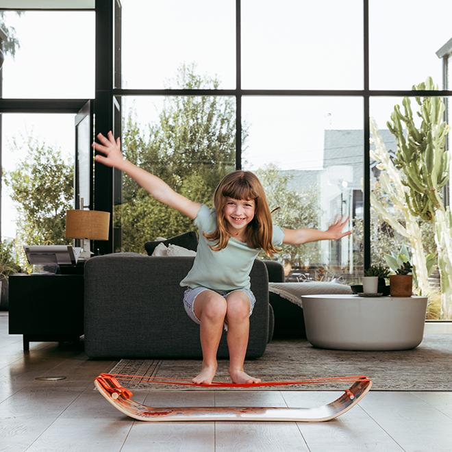 Child playing on a slackboard plus in a modern living room