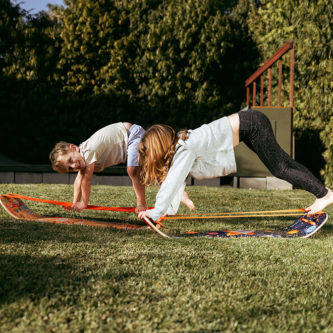 Two children using slackboards outdoors on a grassy area