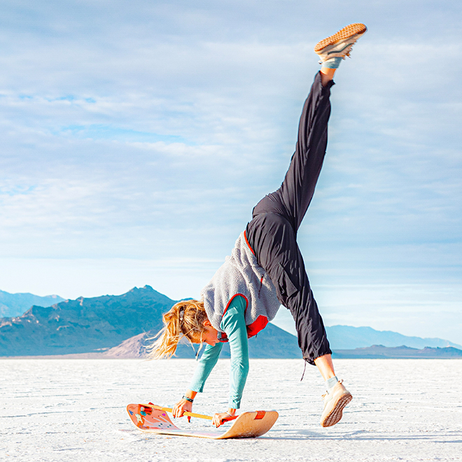 Person doing a handstand on a unicorn slackboard with mountains in the background