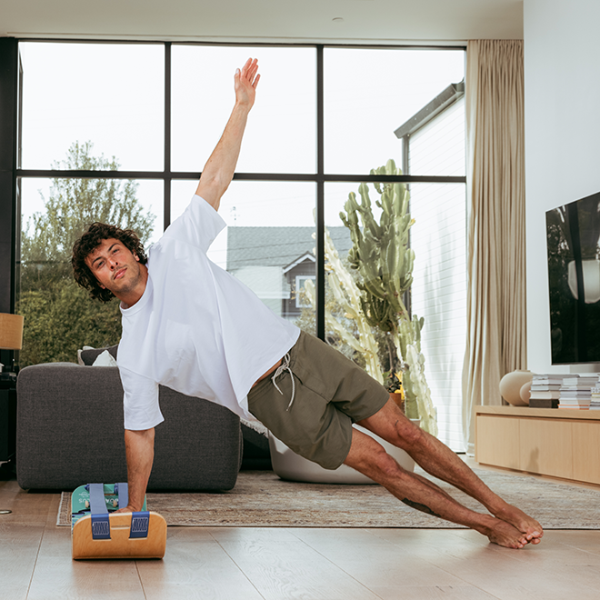 Man doing a side plank using a waves slackboard plus indoors